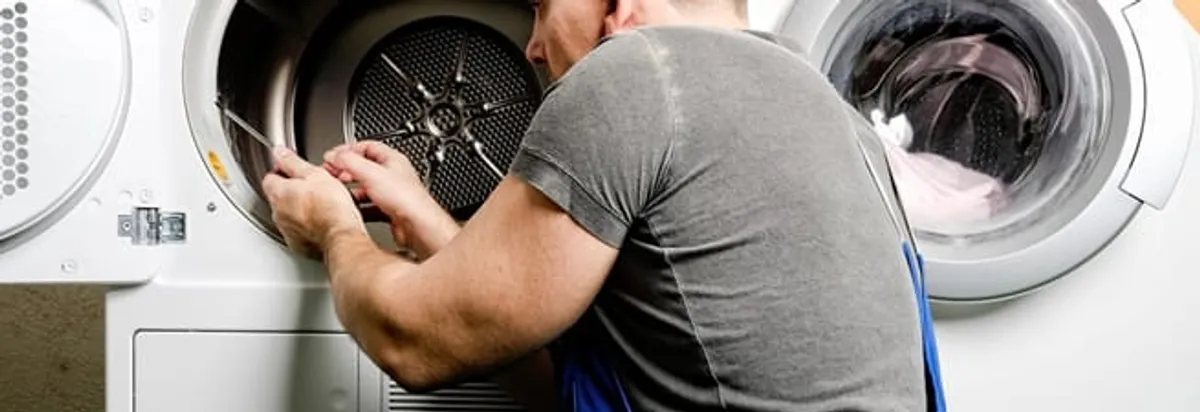 Dryer repair technician fixing a clothes dryer drum in Glendale, AZ