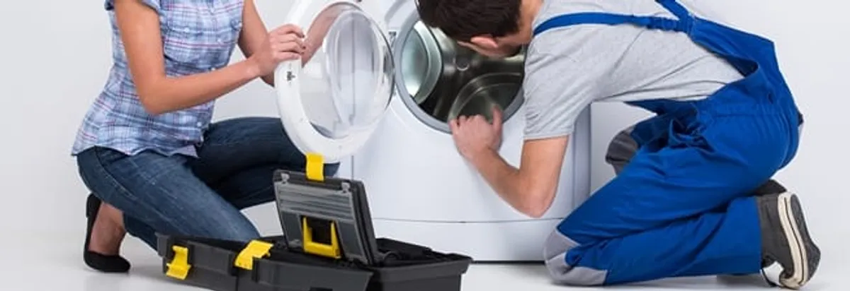 Washer repair technician inspecting a front-load washing machine with tools in Glendale, AZ