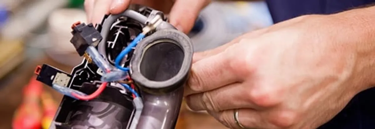 Vacuum repair technician reconnecting wiring and components in Glendale, AZ